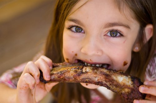 A Little Girl Eating Meat